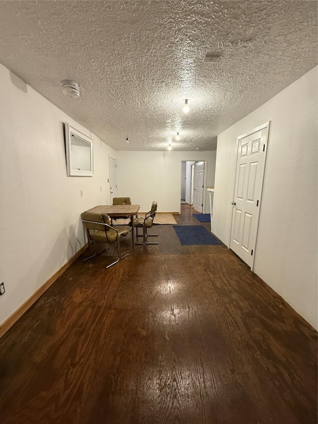 unfurnished dining area with a textured ceiling and wood-type flooring