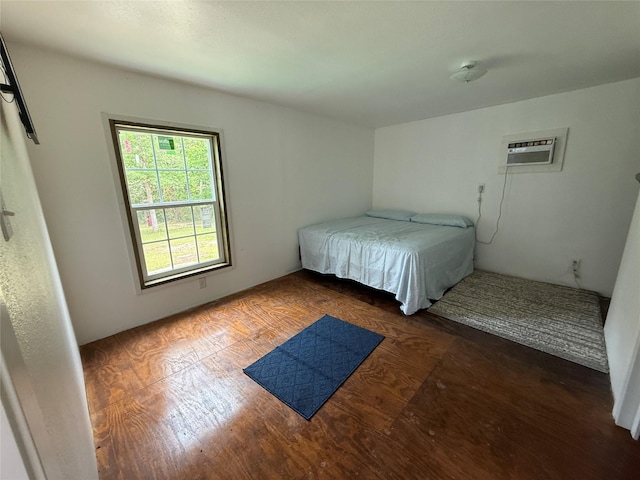 bedroom with wood finished floors and a wall mounted AC
