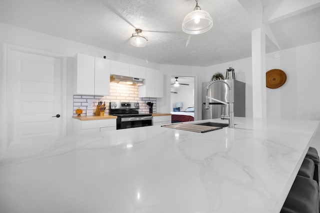 kitchen with white cabinets, a sink, stainless steel electric stove, under cabinet range hood, and backsplash