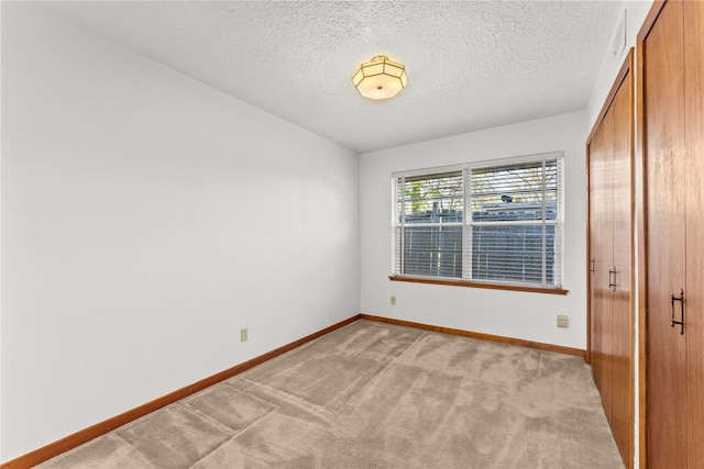 1403 Marlock Ln, Pasadena, TX 77502 - unfurnished bedroom featuring a closet, baseboards, light colored carpet, and a textured ceiling