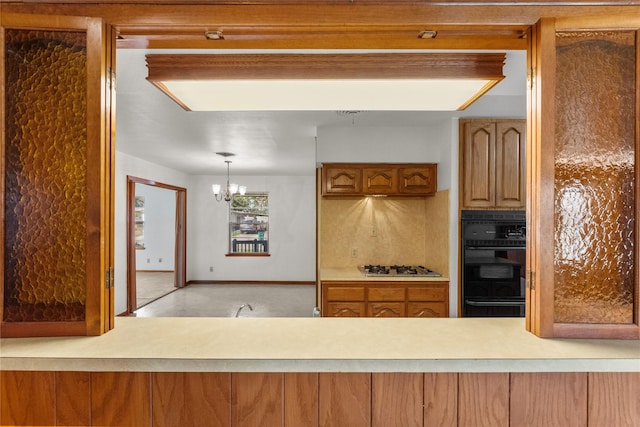1403 Marlock Ln, Pasadena, TX 77502 - kitchen featuring black oven, white gas stovetop, a chandelier, a warming drawer, and light countertops