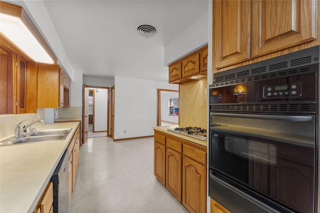 1403 Marlock Ln, Pasadena, TX 77502 - kitchen featuring black oven, a sink, light countertops, white gas cooktop, and baseboards