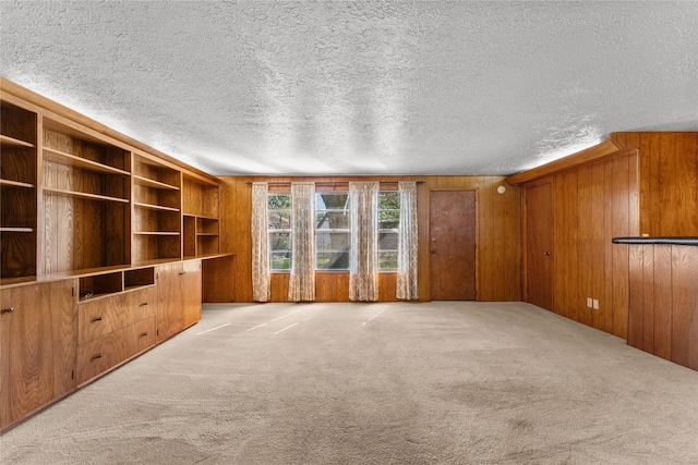 1403 Marlock Ln, Pasadena, TX 77502 - unfurnished living room featuring carpet flooring, a textured ceiling, and wooden walls
