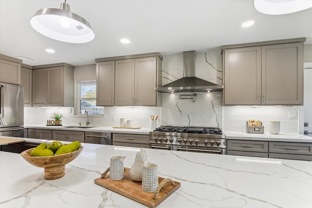 18602 Carriage Ct, Houston, TX 77058 - kitchen with wall chimney exhaust hood, premium appliances, gray cabinetry, a sink, and decorative backsplash