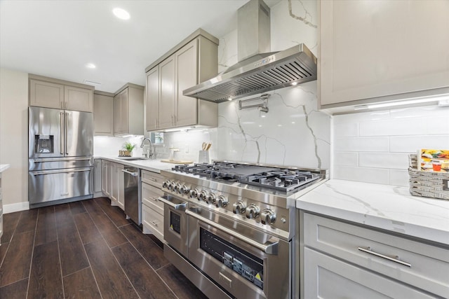 18602 Carriage Ct, Houston, TX 77058 - kitchen with wall chimney range hood, appliances with stainless steel finishes, gray cabinets, light stone counters, and a sink