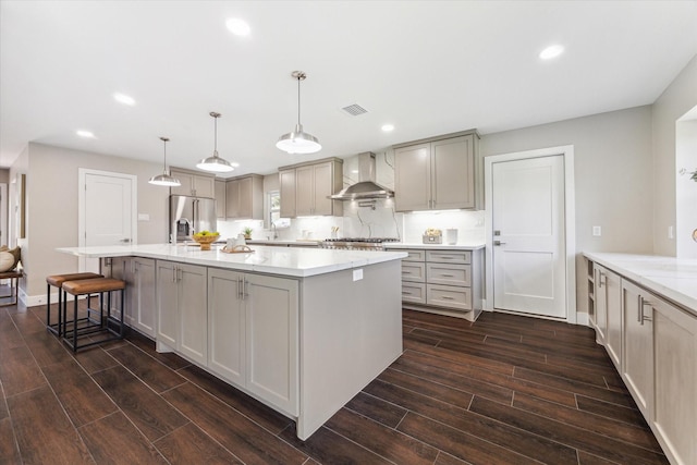 18602 Carriage Ct, Houston, TX 77058 - kitchen with wall chimney range hood, stainless steel appliances, dark wood-style floors, a spacious island, and recessed lighting