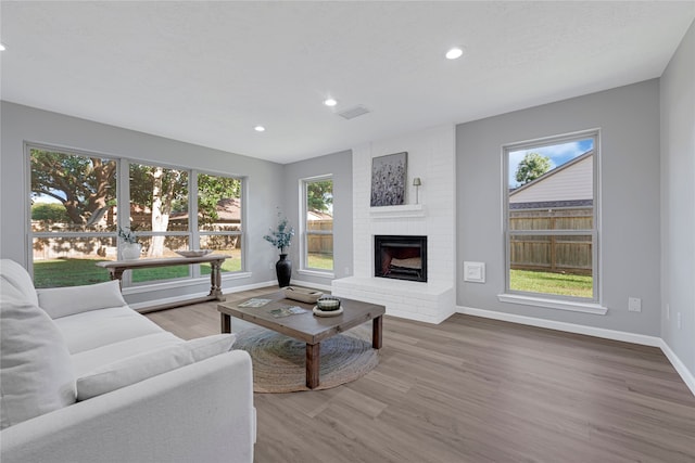 1410 Wesley Ln, Deer Park, TX 77536 - living area featuring healthy amount of natural light, baseboards, recessed lighting, a brick fireplace, and wood finished floors