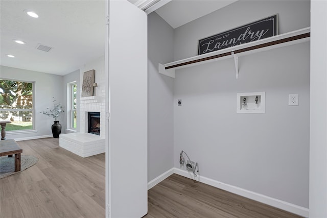 1410 Wesley Ln, Deer Park, TX 77536 - laundry room featuring washer hookup, electric dryer hookup, wood finished floors, recessed lighting, and a fireplace