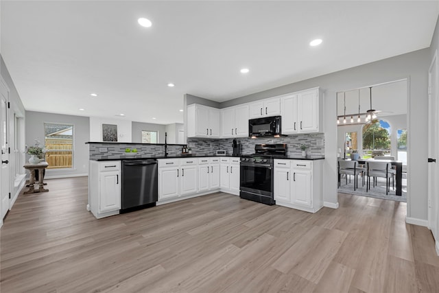1410 Wesley Ln, Deer Park, TX 77536 - kitchen featuring range with gas cooktop, dishwasher, black microwave, dark countertops, and a peninsula