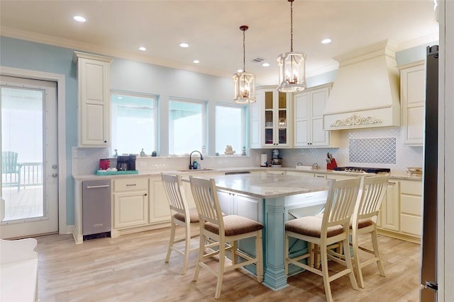 2627 Holiday Dr, Port Bolivar, TX 77650 - kitchen with crown molding, a sink, a chandelier, a kitchen breakfast bar, and premium range hood