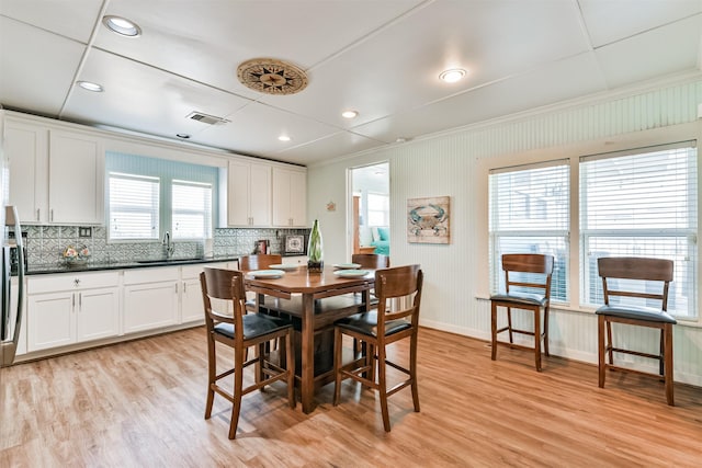 dining room featuring crown molding, light wood finished floors, baseboards, visible vents, and recessed lighting