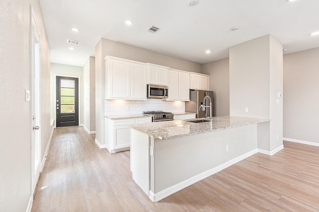 210 Fulton Station Dr, Houston, TX 77009 - kitchen with visible vents, light wood-style flooring, and appliances with stainless steel finishes