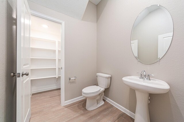 210 Fulton Station Dr, Houston, TX 77009 - half bathroom with toilet, wood finished floors, and baseboards