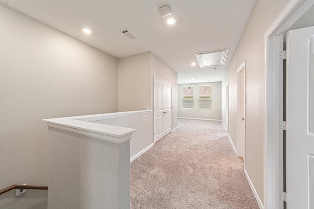 210 Fulton Station Dr, Houston, TX 77009 - hallway featuring visible vents, baseboards, an upstairs landing, attic access, and light carpet