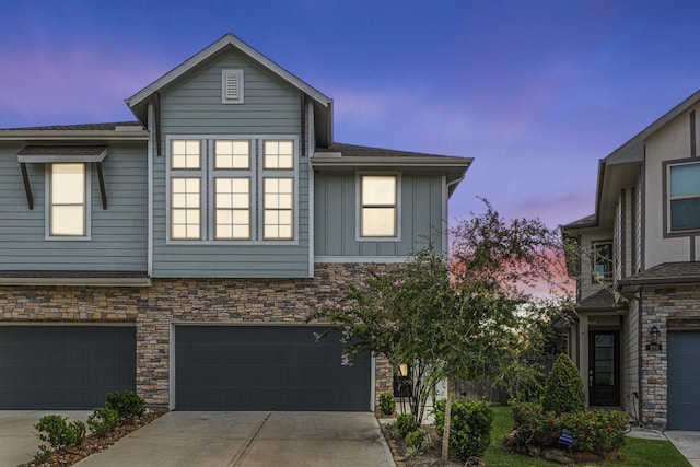 210 Fulton Station Dr, Houston, TX 77009 - view of property featuring driveway, board and batten siding, a garage, and stone siding