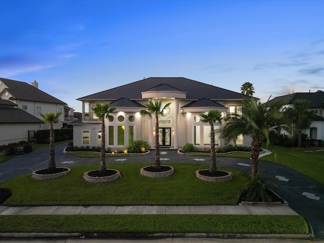 view of front of property with french doors, a front lawn, a standing seam roof, metal roof, and a balcony