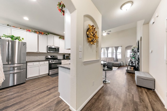 13754 Evansdale Ln, Houston, TX 77083 - kitchen featuring stainless steel appliances, arched walkways, a ceiling fan, dark wood-type flooring, and white cabinets