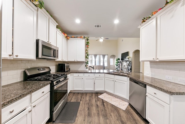 13754 Evansdale Ln, Houston, TX 77083 - kitchen featuring appliances with stainless steel finishes, a sink, a ceiling fan, tasteful backsplash, and white cabinetry