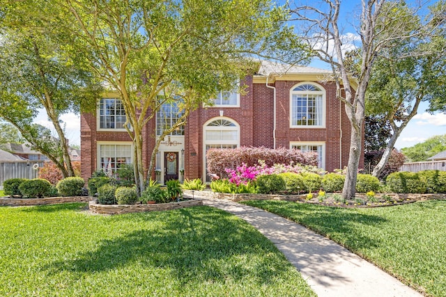 view of front facade featuring brick siding and a front lawn