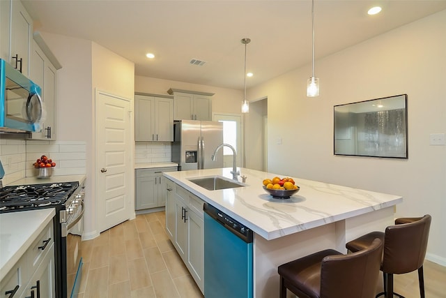 kitchen featuring a sink, appliances with stainless steel finishes, a center island with sink, visible vents, and recessed lighting