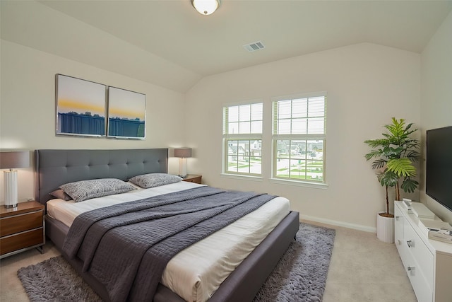 bedroom with baseboards, lofted ceiling, visible vents, and light colored carpet