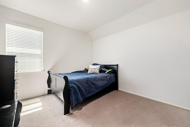 carpeted bedroom featuring vaulted ceiling and baseboards