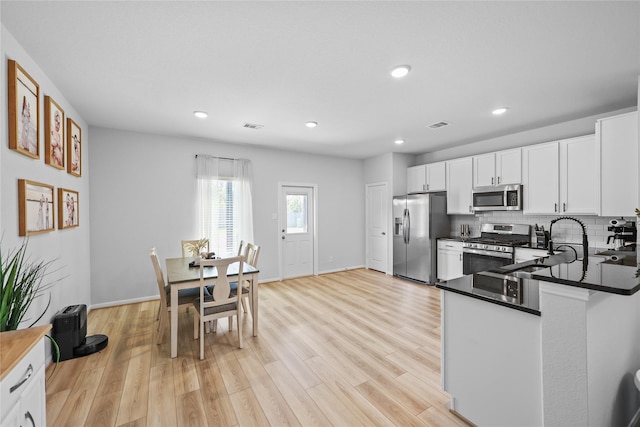 30208 Arnold Branch Dr, Magnolia, TX 77355 - kitchen with recessed lighting, white cabinets, a sink, light wood-style flooring, and appliances with stainless steel finishes