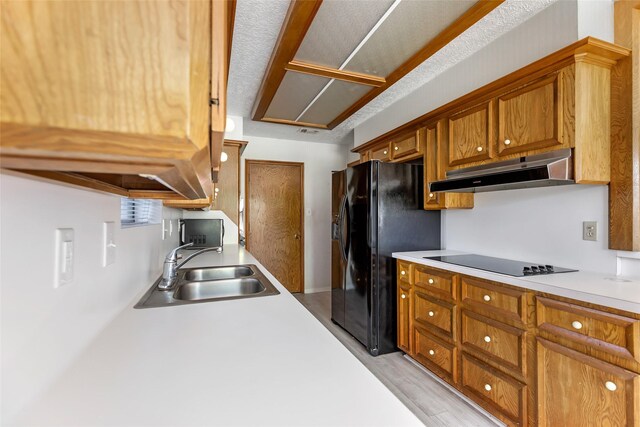 16002 Castaway Ct, Crosby, TX 77532 - kitchen featuring a sink, under cabinet range hood, black appliances, and light countertops