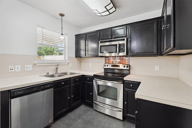 18911 Brownstone Mills Dr, Cypress, TX 77433 - kitchen with appliances with stainless steel finishes, a sink, dark cabinets, light countertops, and pendant lighting