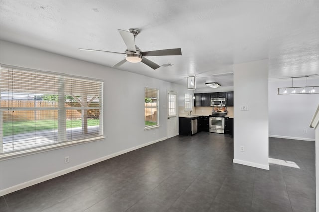 18911 Brownstone Mills Dr, Cypress, TX 77433 - unfurnished living room featuring ceiling fan, baseboards, a sink, and dark tile patterned flooring