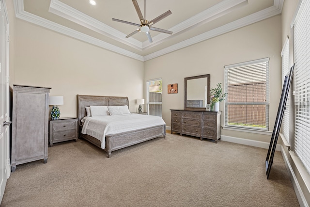 bedroom featuring multiple windows, carpet flooring, ornamental molding, and a tray ceiling