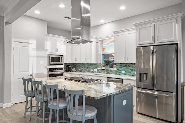 kitchen with a sink, tasteful backsplash, a center island, stainless steel appliances, and island range hood