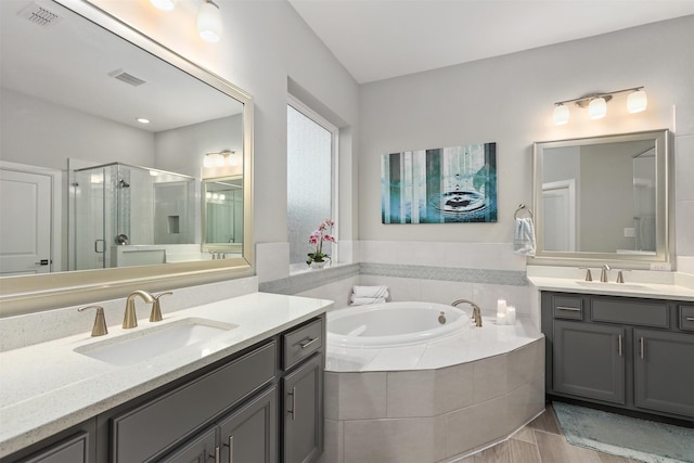 full bath featuring a stall shower, visible vents, a sink, and a garden tub