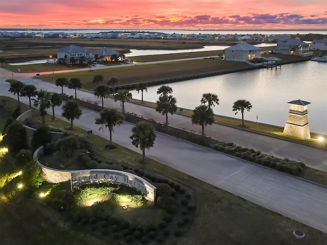 aerial view at dusk featuring a water view