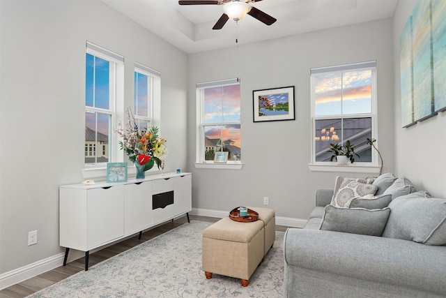 living room with wood finished floors, baseboards, and ceiling fan