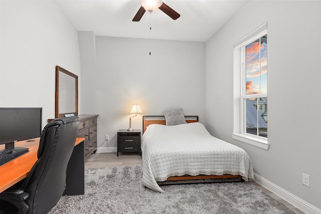 bedroom with a ceiling fan, light wood-style floors, and baseboards