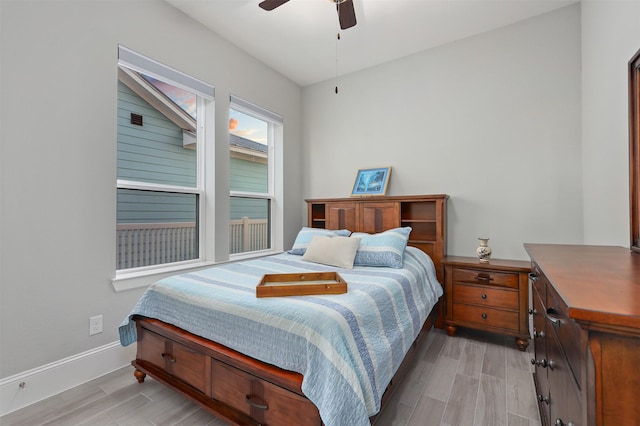 bedroom with a ceiling fan, baseboards, and light wood-type flooring