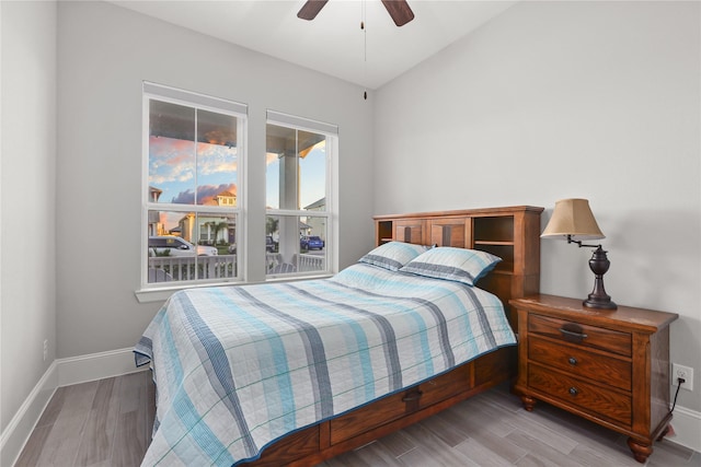 bedroom featuring light wood finished floors, baseboards, and ceiling fan