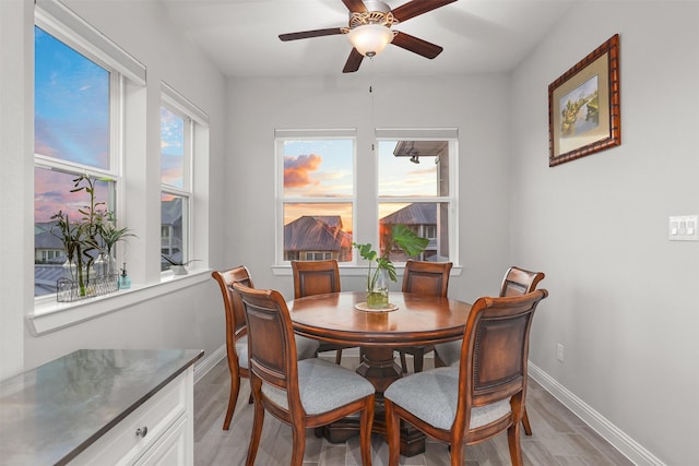 dining space featuring baseboards, a ceiling fan, and light wood-type flooring