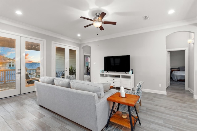 living area featuring arched walkways, french doors, and a ceiling fan
