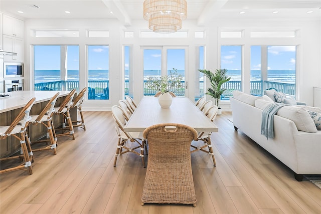 11367 Beachside Dr, Galveston, TX 77554 - dining area with a water view, a notable chandelier, beam ceiling, and a healthy amount of sunlight