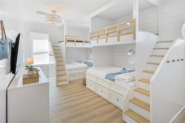 11367 Beachside Dr, Galveston, TX 77554 - bedroom featuring recessed lighting, wood walls, and light wood-style floors