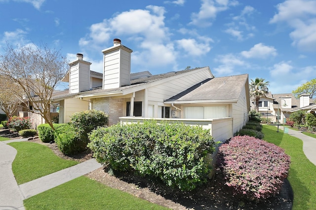 view of property exterior with a chimney and a garage