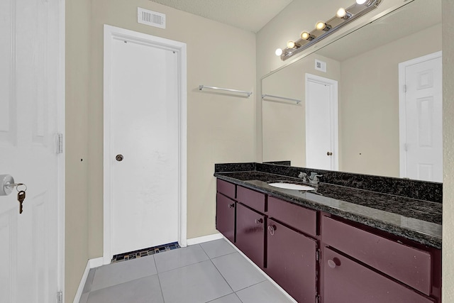 bathroom featuring baseboards, visible vents, tile patterned floors, and vanity