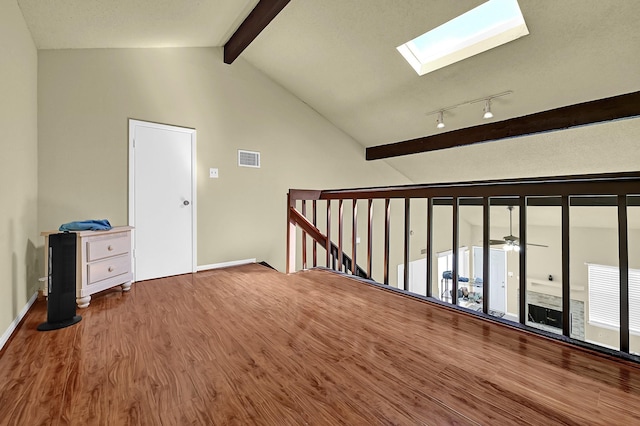 additional living space featuring ceiling fan, visible vents, wood finished floors, and lofted ceiling with skylight