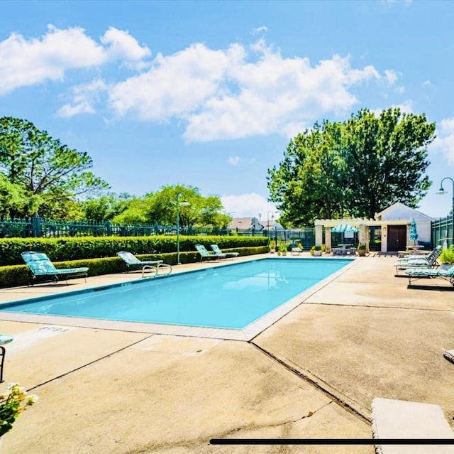 pool featuring fence and a patio area