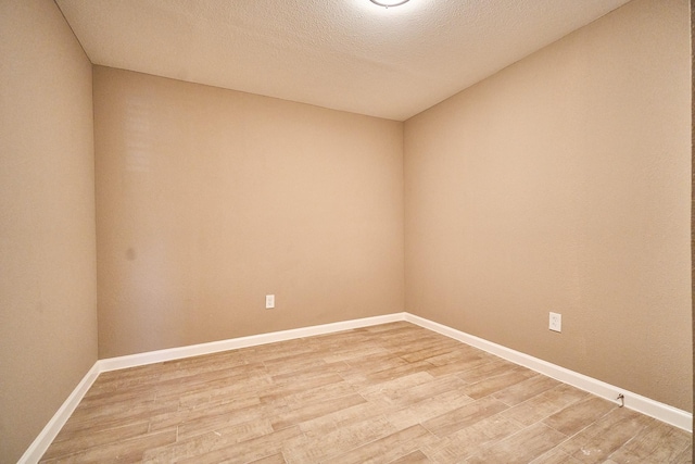 12234 Dumas St, Houston, TX 77034 - empty room featuring light wood-style floors, baseboards, and a textured ceiling