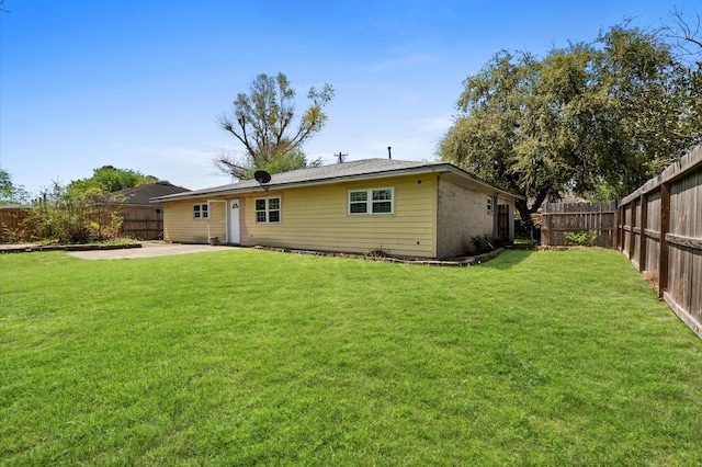 5401 Bayou Dr, Dickinson, TX 77539 - back of property featuring a fenced backyard, a lawn, and a patio