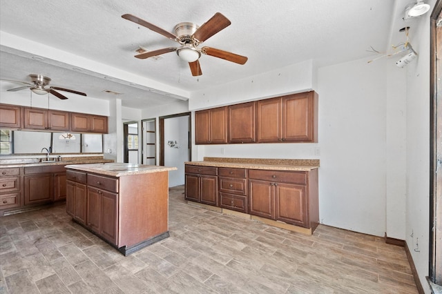 5401 Bayou Dr, Dickinson, TX 77539 - kitchen featuring light wood finished floors, a textured ceiling, light countertops, and a ceiling fan
