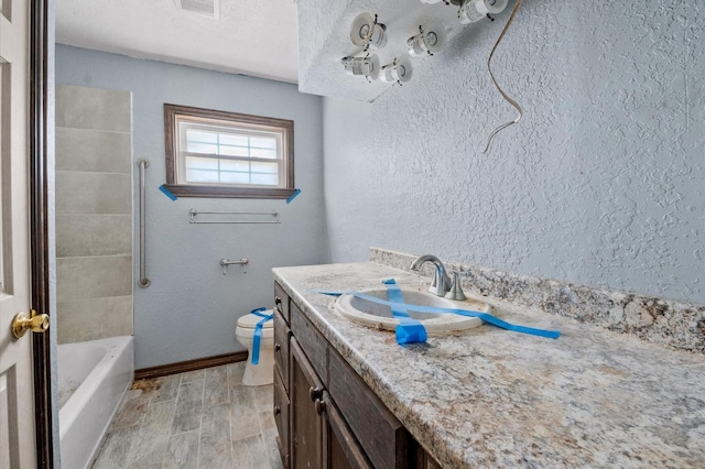 5401 Bayou Dr, Dickinson, TX 77539 - bathroom featuring a textured wall, wood tiled floor, toilet, and vanity